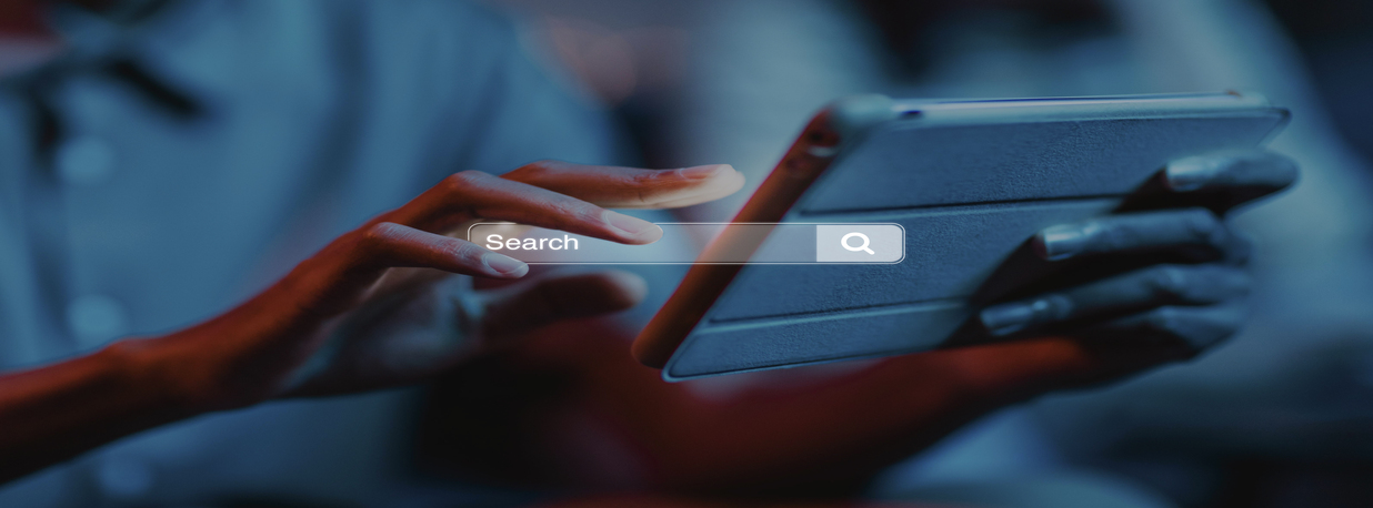 Person using tablet with a search bar on the screen